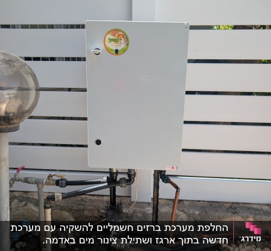 ארון חשמל ליד גדר לבנה ואבנים